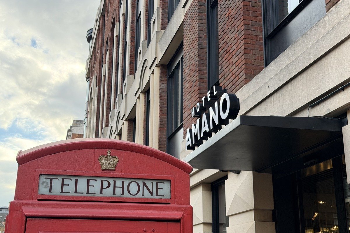 Cabine téléphonique rouge devant la façade de l'hôtel Amano