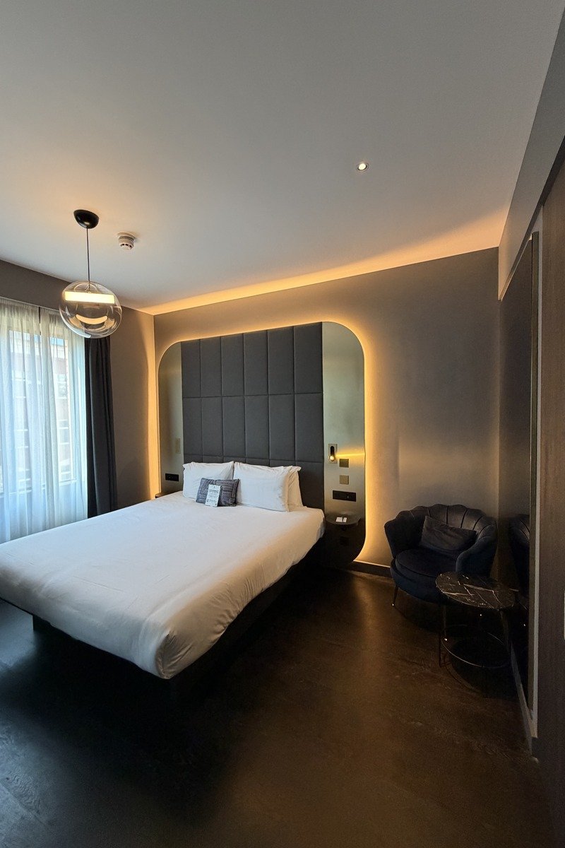 Chambre d'hôtel design avec grand lit blanc et tête de lit rétroéclairée
