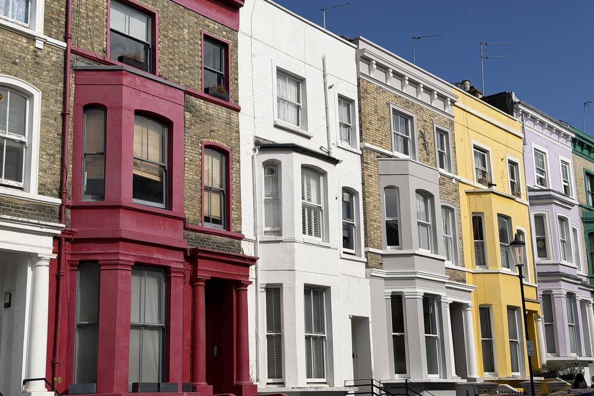 Rangée de maisons victoriennes aux façades colorées sous ciel bleu