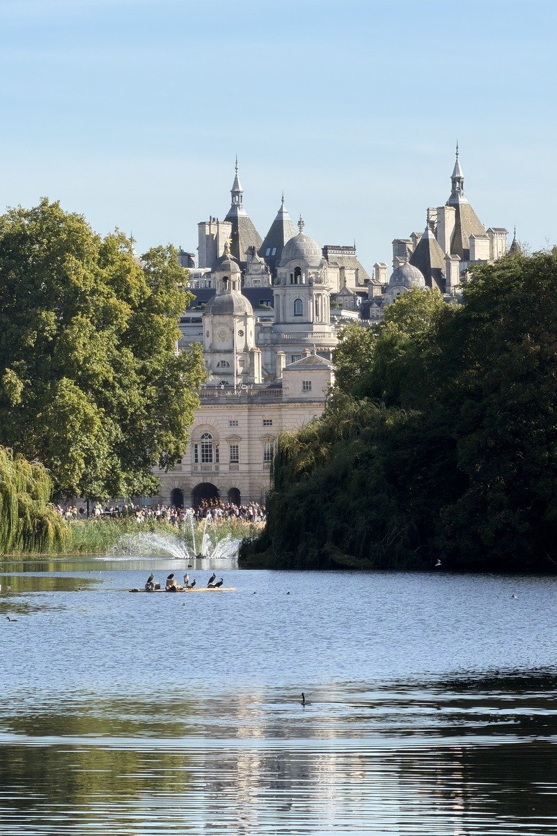 Lac avec fontaine, bâtiment à dômes et arbres en arrière-plan