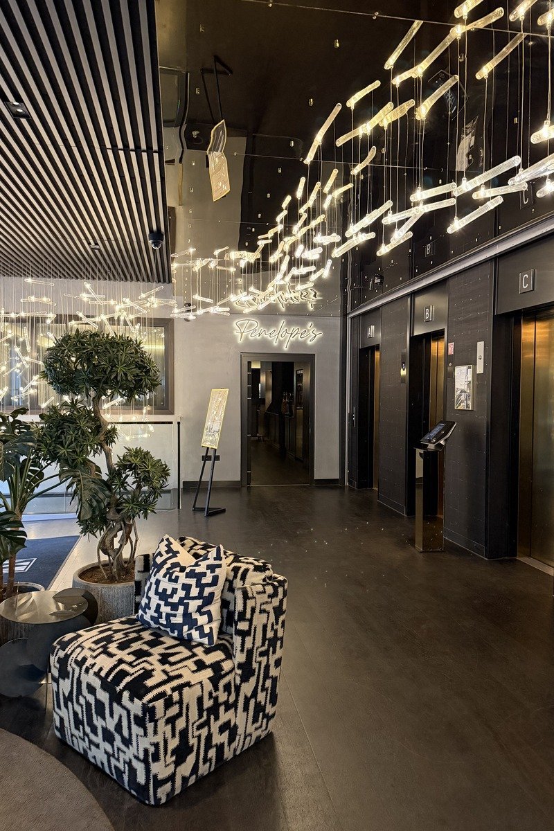 Hall d'hôtel design avec fauteuil graphique et installation lumineuse suspendue