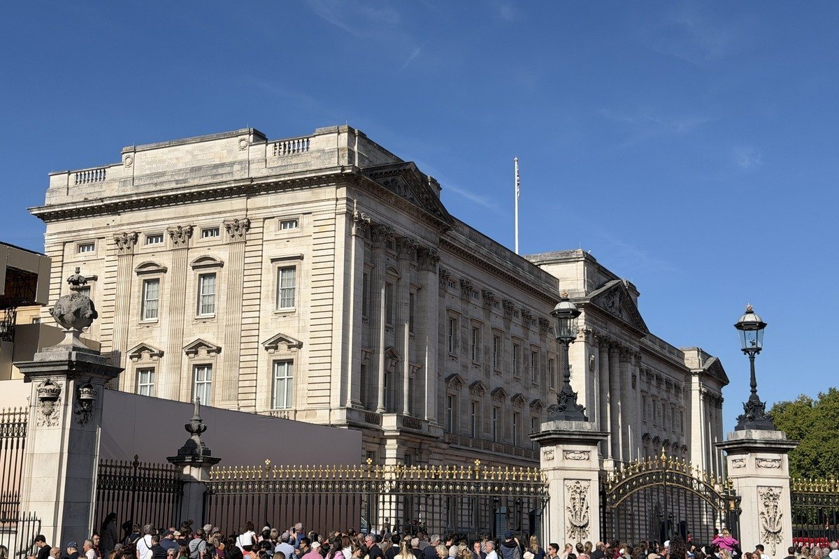 Façade d'un grand palais néoclassique avec foule devant les grilles dorées