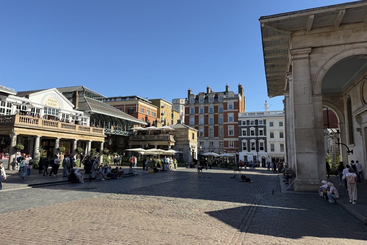 Place pavée animée avec marché couvert et bâtiments géorgiens sous ciel bleu