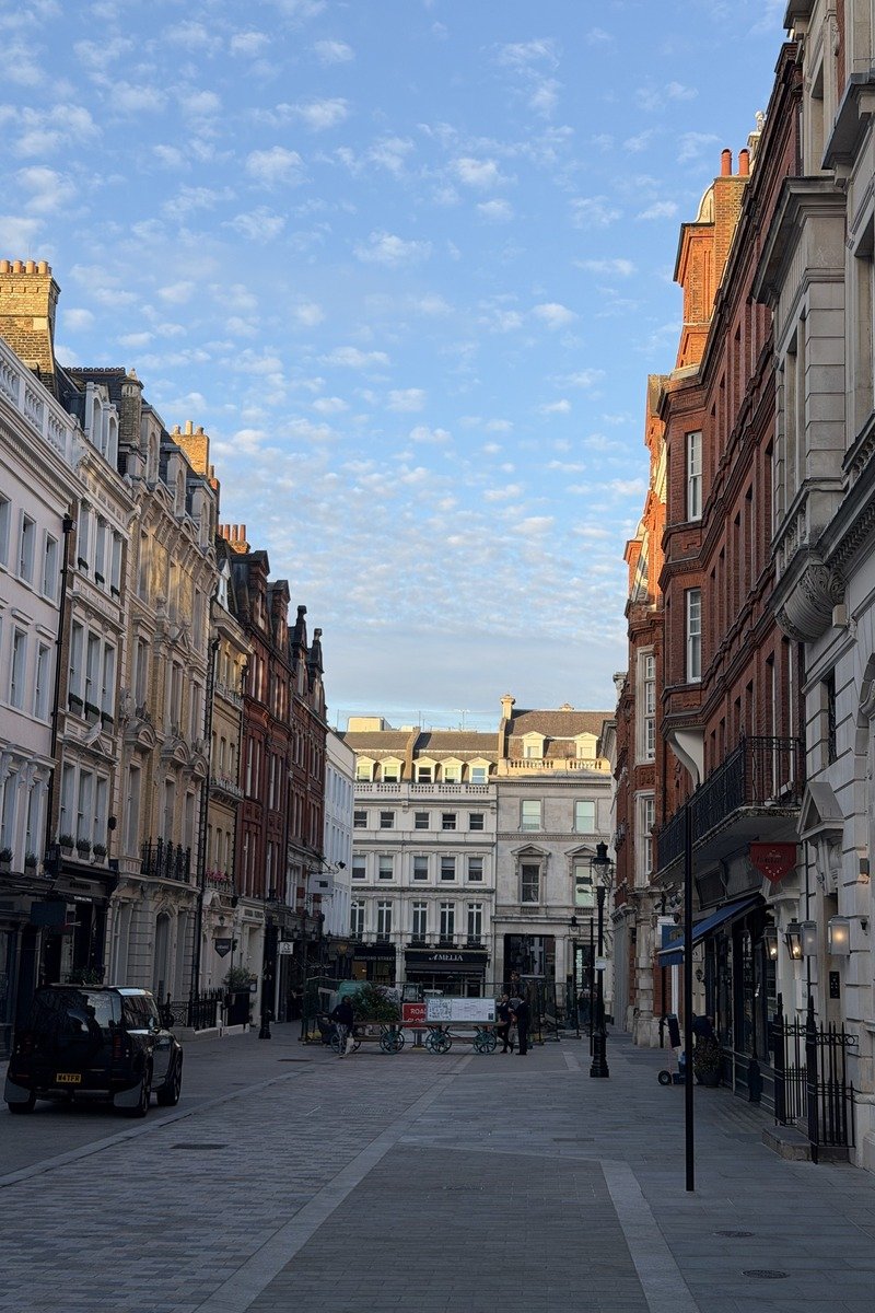 Rue piétonne bordée de façades historiques sous un ciel nuageux matinal