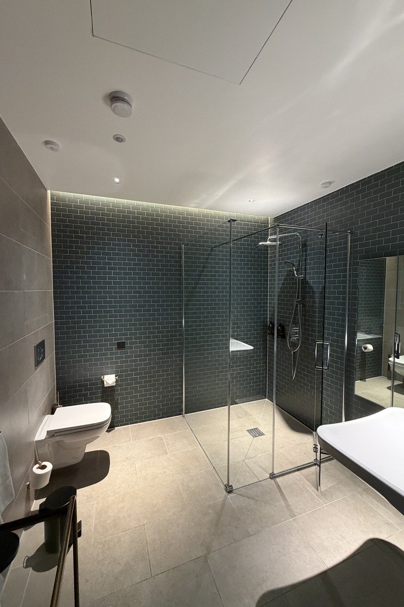 Salle de bain moderne avec douche vitrée et carrelage sombre