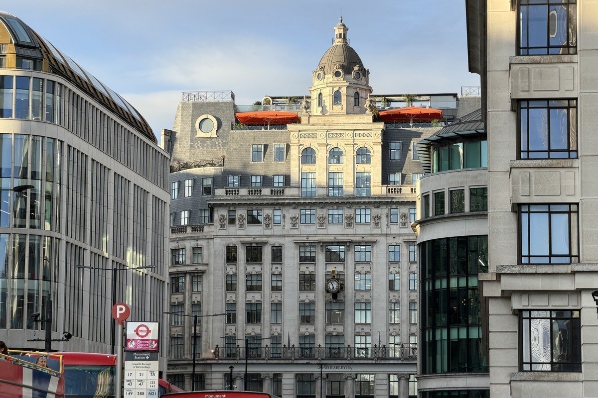 Façades d'immeubles classiques avec dôme et bus rouge au premier plan
