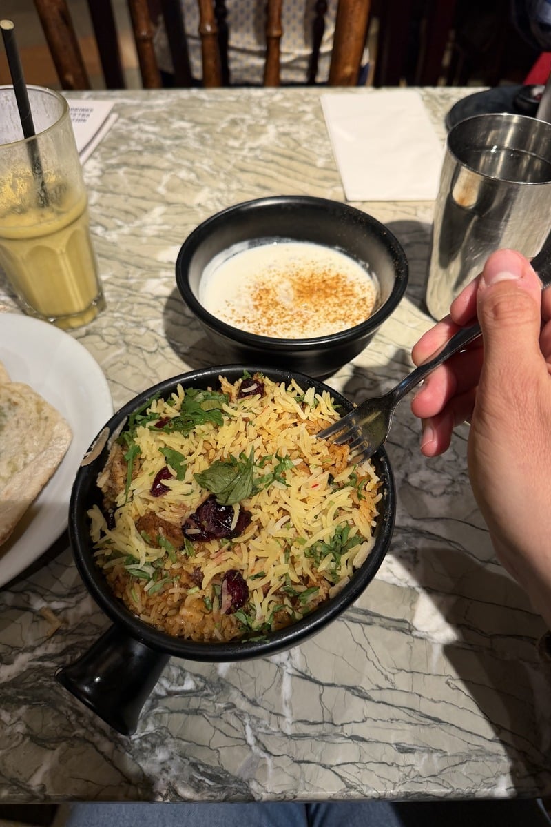 Bol de biryani au riz épicé garni de coriandre sur table marbre
