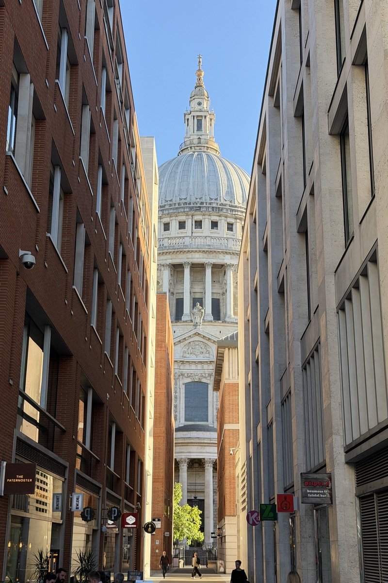 Dôme d'une cathédrale baroque vu depuis une ruelle encadrée d'immeubles