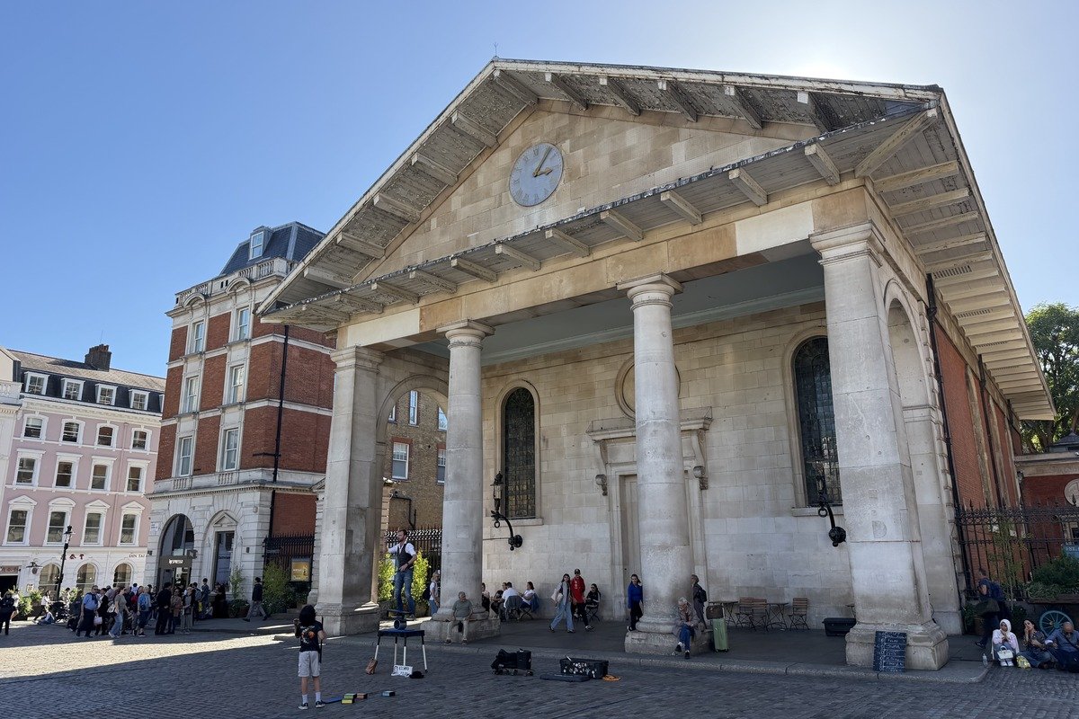 Façade à colonnes d'une église classique avec artiste de rue devant