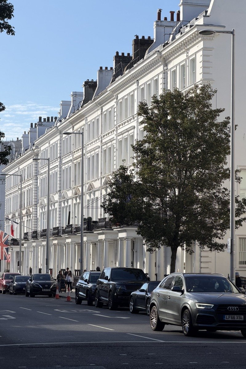 Rangée de façades blanches géorgiennes avec voitures garées et drapeau britannique