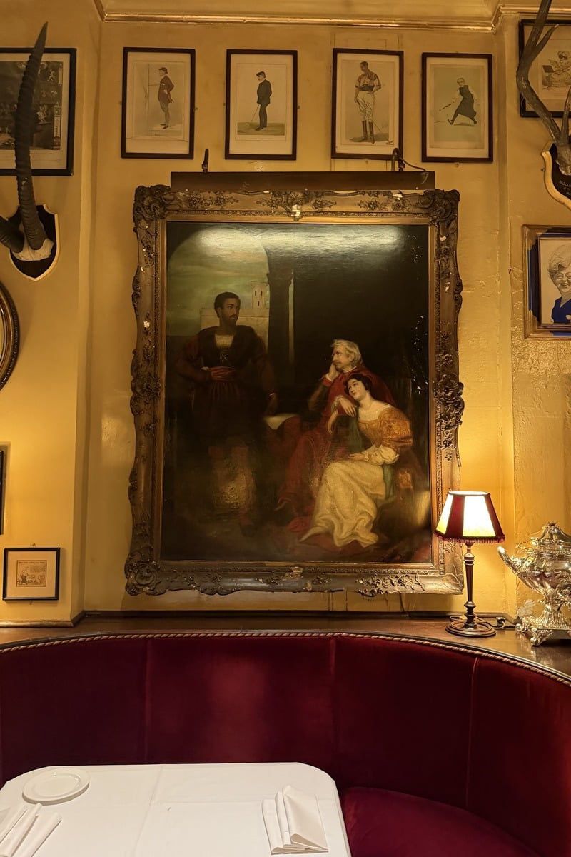 Intérieur de restaurant avec grand tableau ancien et banquette rouge