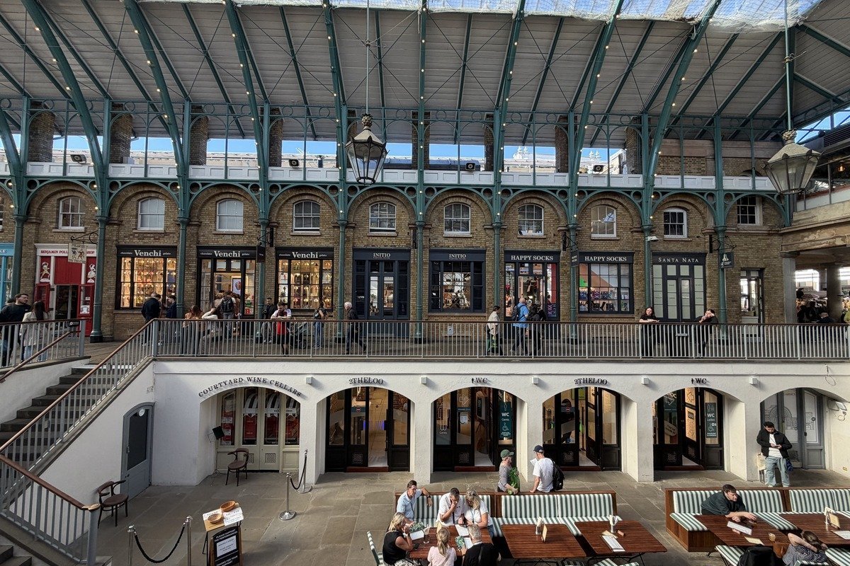 Intérieur d'un marché couvert avec arcades en brique et terrasse animée