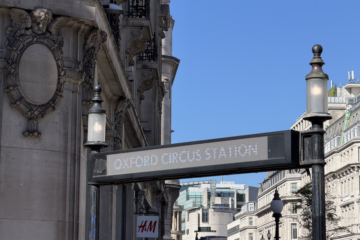 Panneau lumineux de station de métro entre façades classiques et ciel bleu