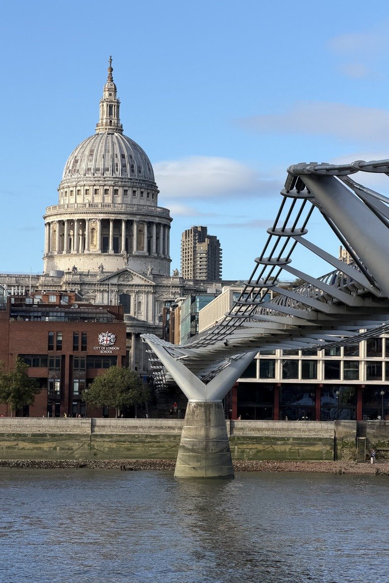 Pont métallique suspendu face à une cathédrale à dôme classique